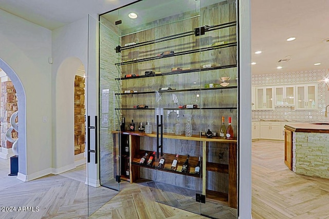 wine cellar with sink and light parquet flooring