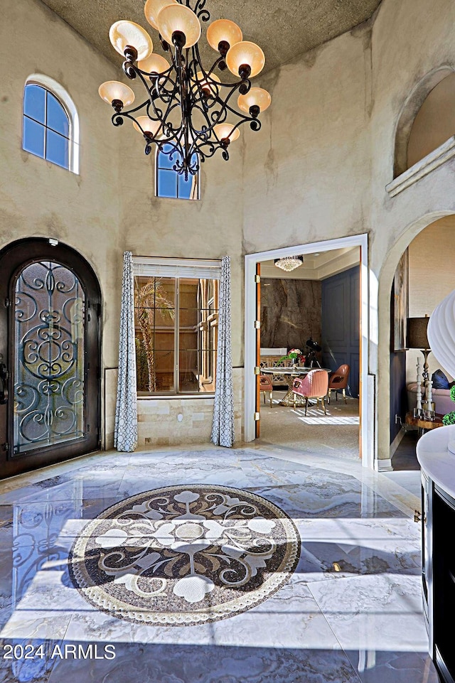 foyer entrance with a chandelier and a towering ceiling