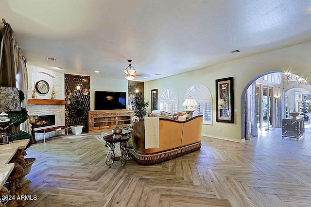 living room featuring a large fireplace, a healthy amount of sunlight, and light parquet floors