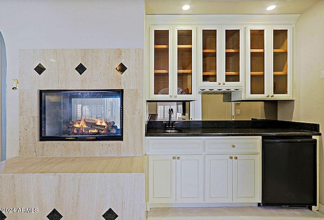 kitchen with fridge, white cabinets, and sink