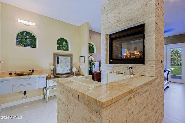 interior space featuring a multi sided fireplace and white cabinetry