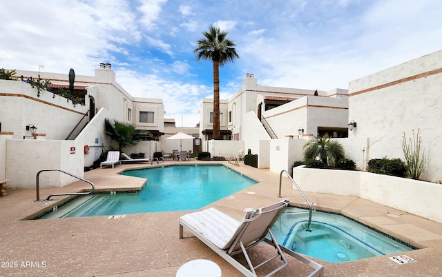 view of swimming pool with a hot tub and a patio