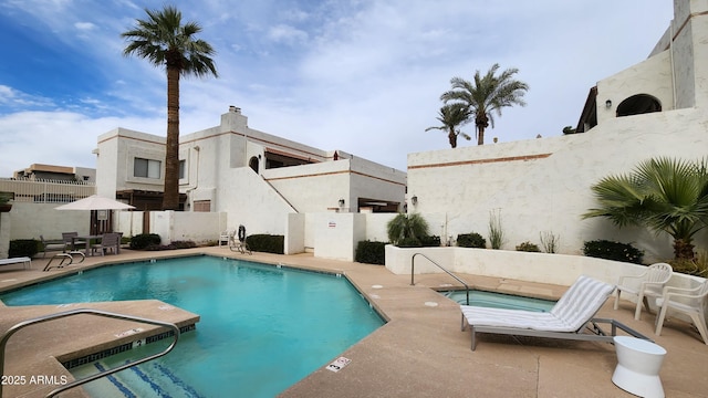 view of pool featuring a hot tub and a patio area