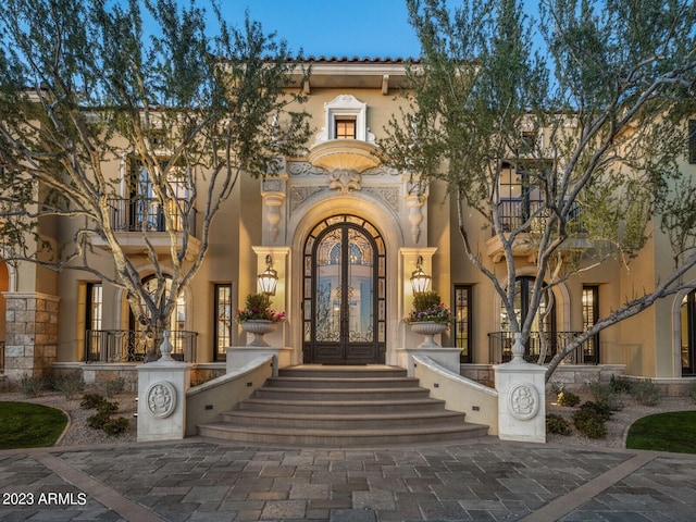 view of exterior entry featuring stucco siding and french doors