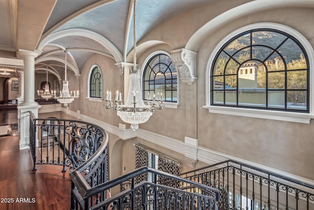 stairs featuring a chandelier, decorative columns, and a towering ceiling