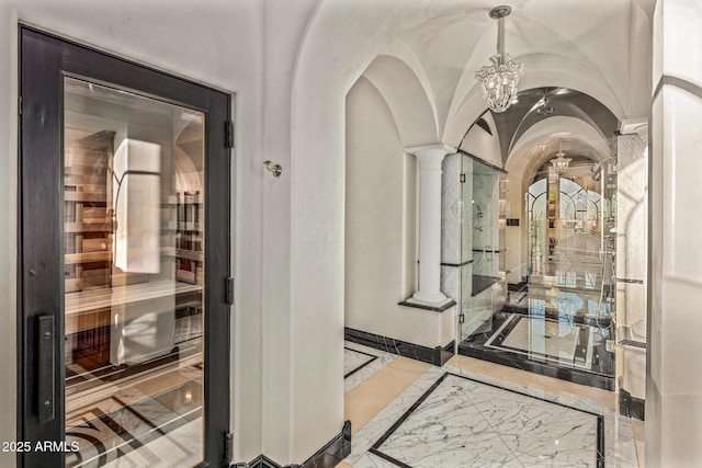 interior space featuring lofted ceiling, marble finish floor, decorative columns, and a sauna