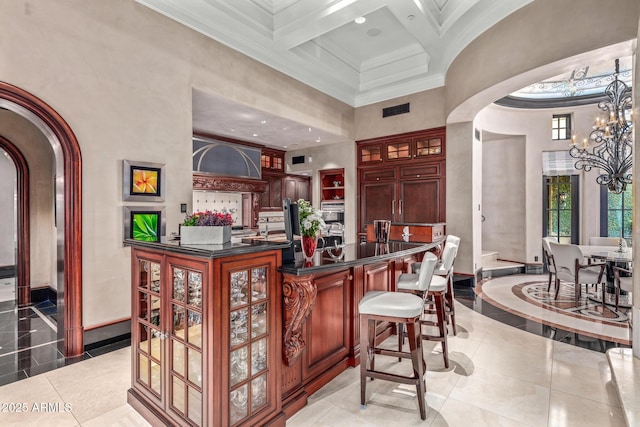 bar with visible vents, a high ceiling, arched walkways, and crown molding