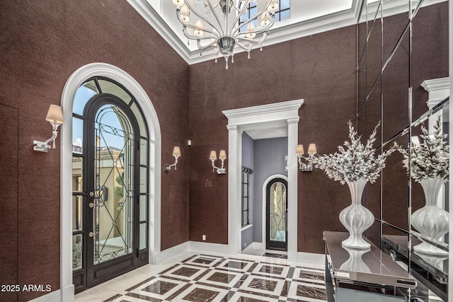 entrance foyer featuring arched walkways, an inviting chandelier, and baseboards