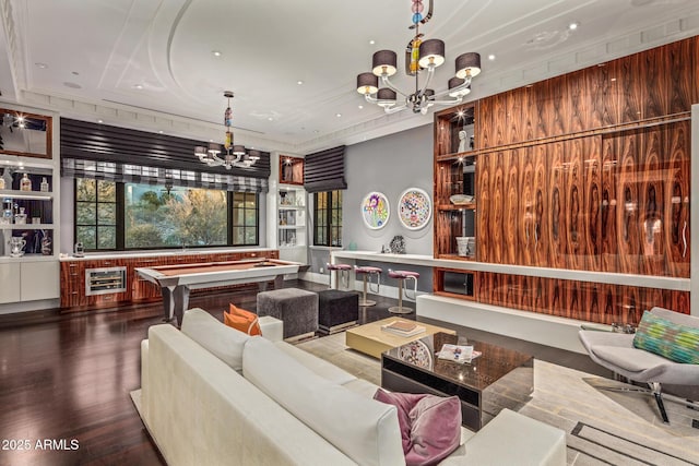 recreation room with built in features, wood finished floors, beverage cooler, and an inviting chandelier