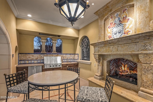 sitting room featuring a large fireplace, ornamental molding, arched walkways, and recessed lighting