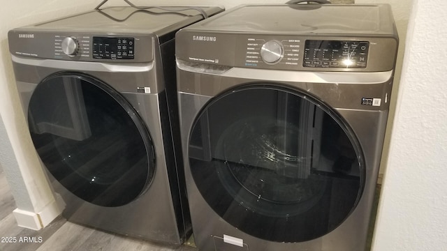 laundry room with independent washer and dryer and wood finished floors