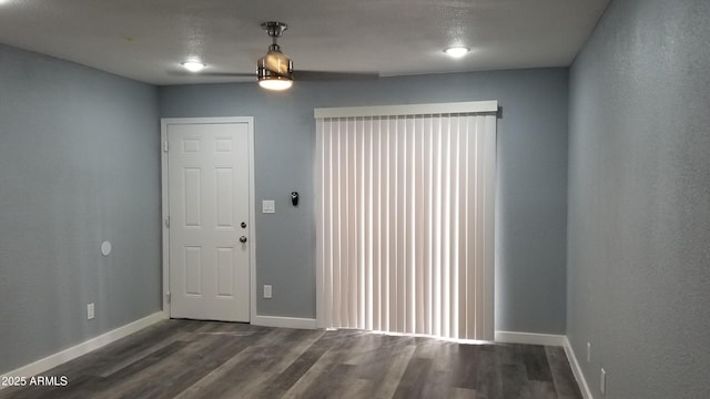 foyer entrance with dark wood-style flooring and baseboards