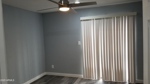 empty room with dark wood-type flooring, ceiling fan, and baseboards