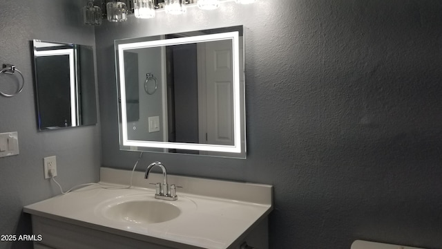 bathroom with vanity and a textured wall