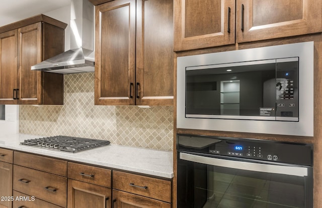 kitchen featuring appliances with stainless steel finishes, wall chimney exhaust hood, and backsplash