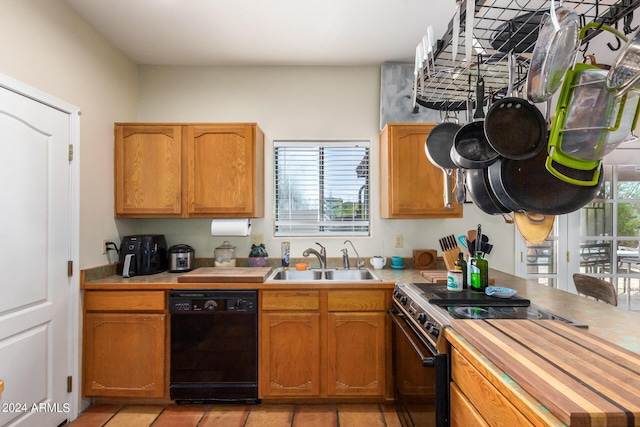 kitchen with a sink, light countertops, electric range oven, and black dishwasher