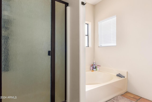 bathroom featuring a bath, a shower stall, and tile patterned flooring