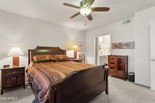 bedroom featuring light colored carpet, connected bathroom, and a ceiling fan