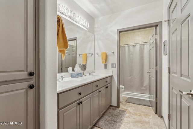 bathroom with toilet, double vanity, a shower with curtain, and stone finish floors