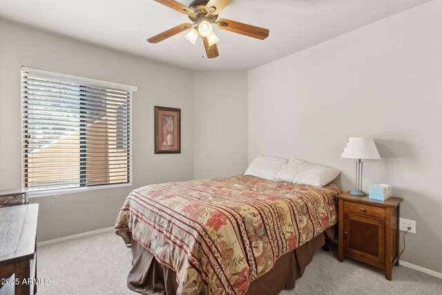 bedroom featuring light colored carpet, baseboards, and a ceiling fan