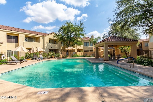 community pool featuring a gazebo, fence, and a patio area