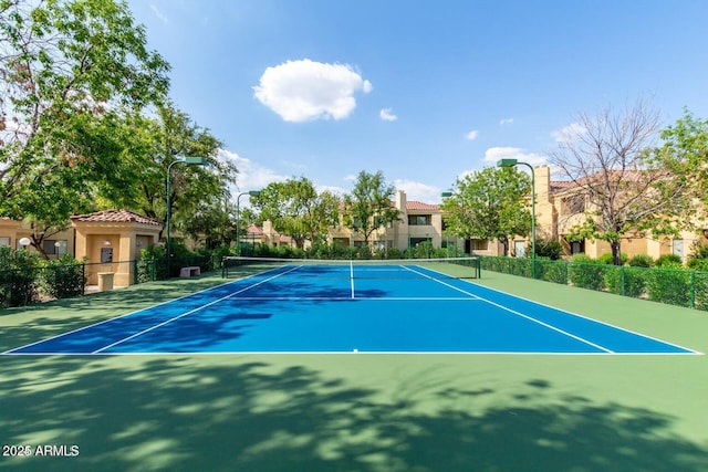 view of tennis court featuring fence and community basketball court