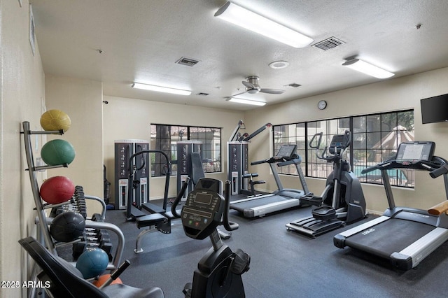 workout area with a textured ceiling and ceiling fan