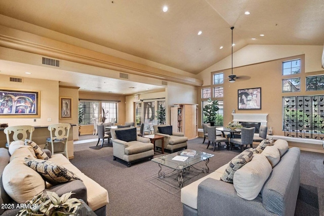 living room featuring carpet floors, recessed lighting, high vaulted ceiling, a glass covered fireplace, and a ceiling fan
