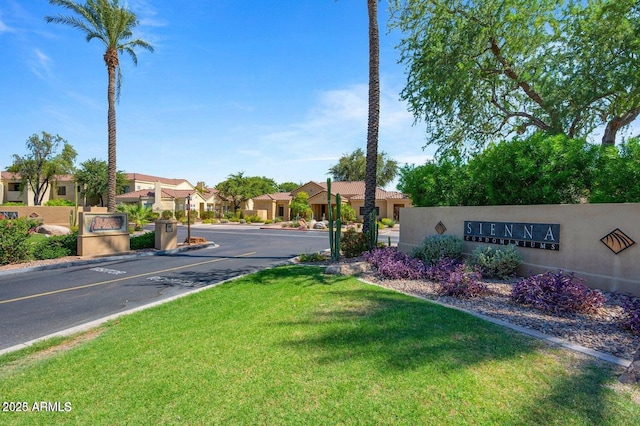 view of asphalt road featuring a residential view and curbs