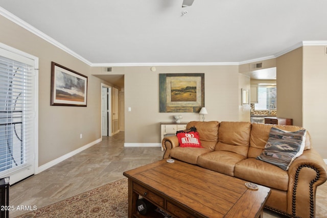 living room with baseboards, crown molding, and ceiling fan