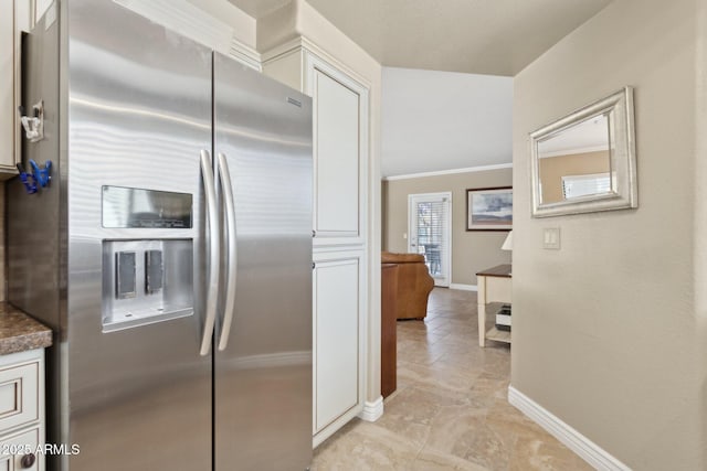 kitchen featuring stainless steel fridge with ice dispenser, baseboards, white cabinetry, dark countertops, and crown molding