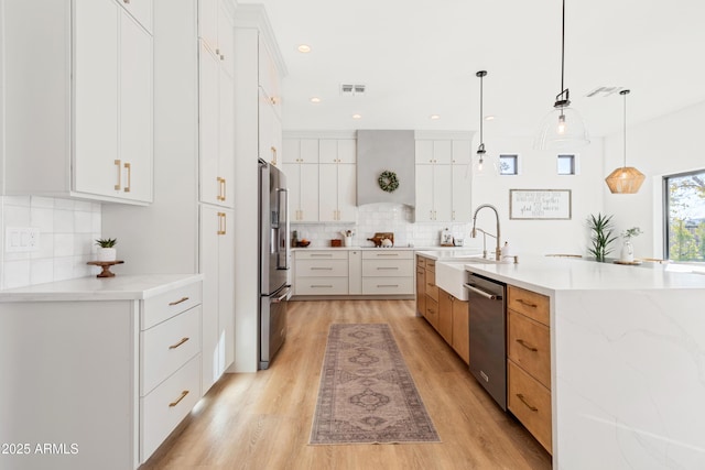 kitchen with decorative light fixtures, white cabinetry, and appliances with stainless steel finishes