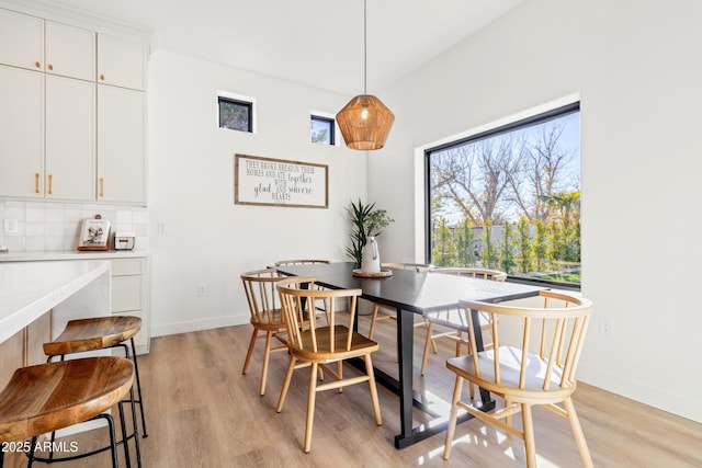 dining room with light wood-type flooring and a healthy amount of sunlight