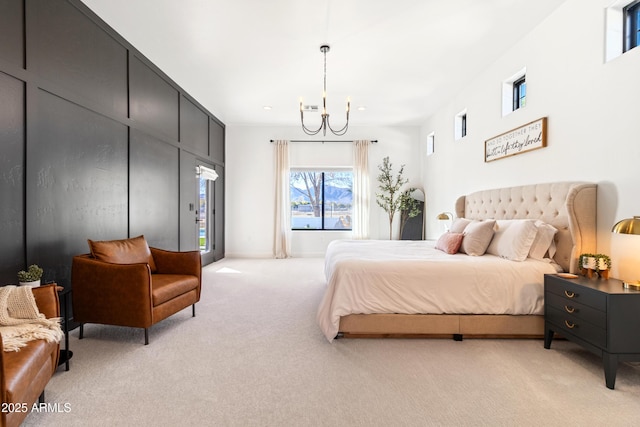 carpeted bedroom featuring access to exterior and an inviting chandelier