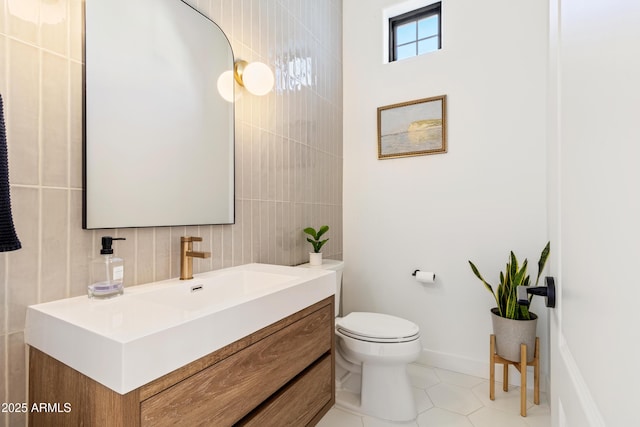 bathroom with tile patterned flooring, vanity, decorative backsplash, tile walls, and toilet