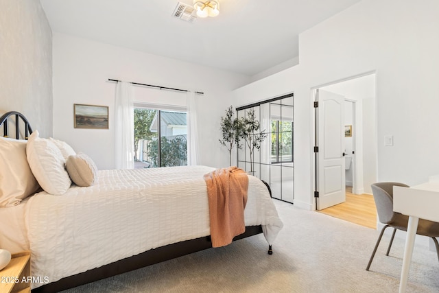 bedroom with access to outside and light carpet