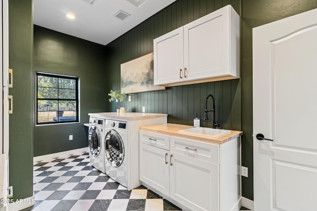 clothes washing area with cabinets, sink, and washer and dryer