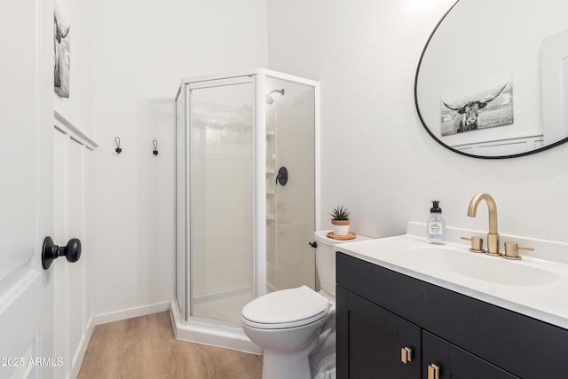 bathroom with wood-type flooring, toilet, a shower with door, and vanity