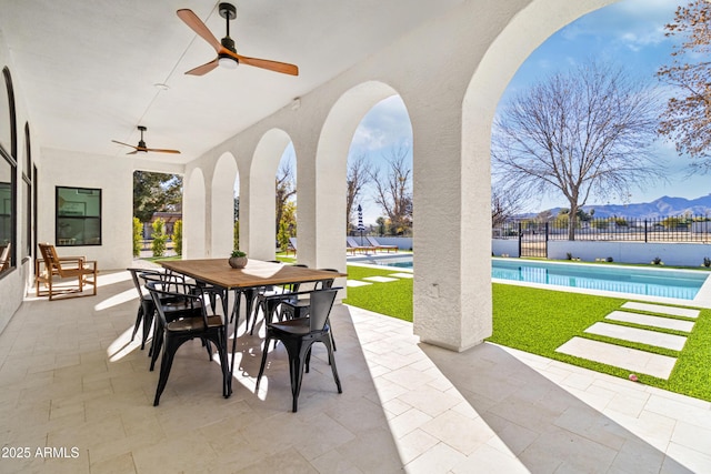 view of patio / terrace with a mountain view, a fenced in pool, and ceiling fan