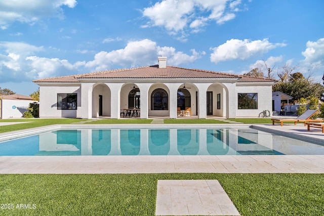 back of house with a patio area and a lawn