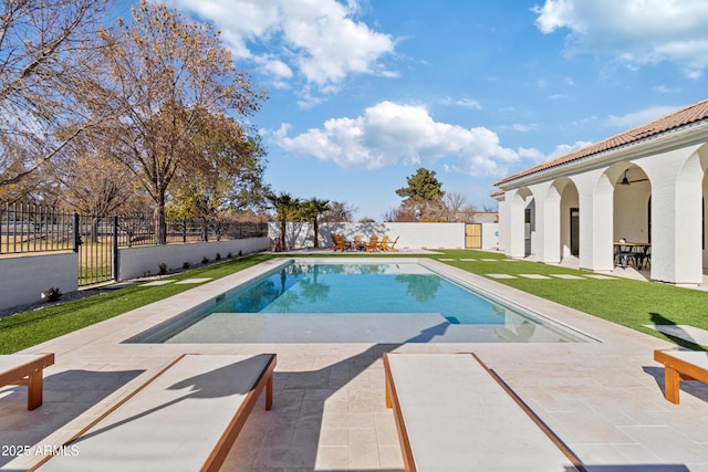 view of swimming pool featuring ceiling fan, a patio, and a yard