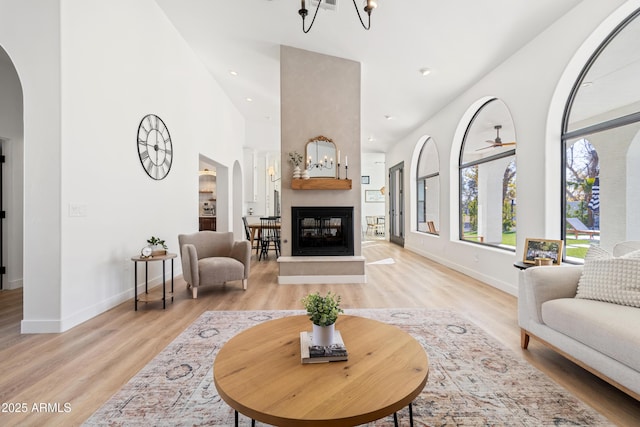 living room with light wood-type flooring, a notable chandelier, and a fireplace