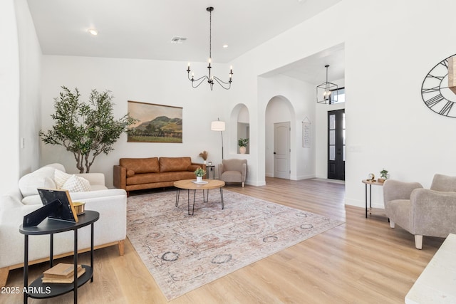 living room with a notable chandelier and light hardwood / wood-style floors