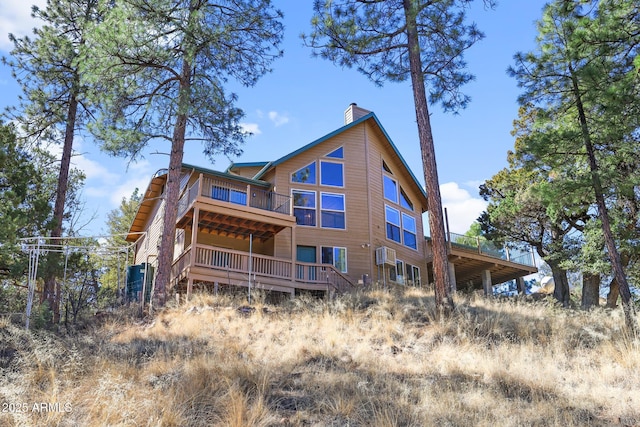 rear view of property featuring a deck and a chimney