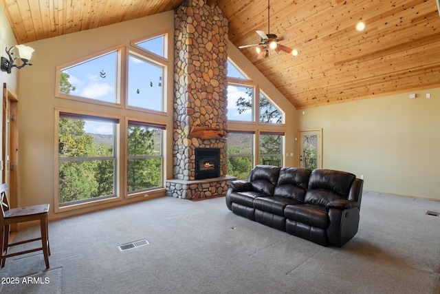 6602 W Dogwood Ln, Pine, AZ 85544 - carpeted living room featuring a stone fireplace, visible vents, wood ceiling, and a ceiling fan