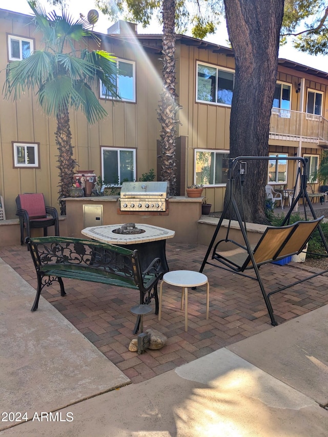 view of patio with area for grilling and a balcony