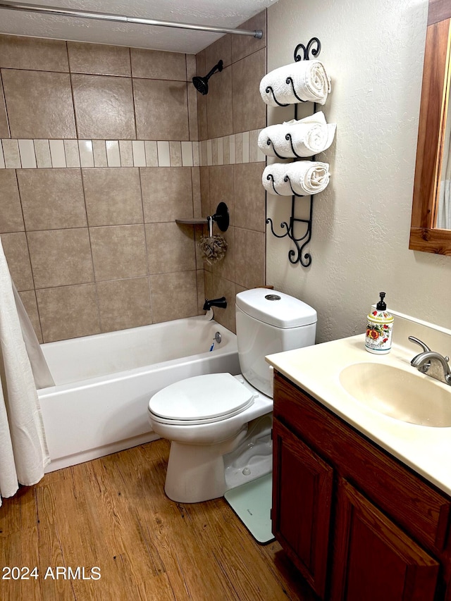 full bathroom featuring vanity, toilet, shower / bath combo, a textured ceiling, and hardwood / wood-style floors