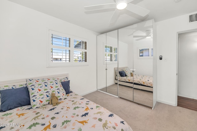 carpeted bedroom with ceiling fan and a closet