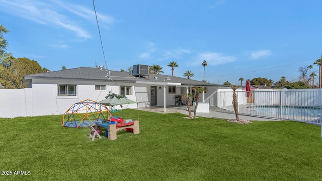 back of house with a fenced in pool, a patio area, cooling unit, and a yard