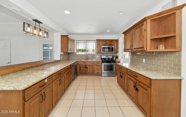 kitchen with decorative light fixtures, tasteful backsplash, kitchen peninsula, sink, and appliances with stainless steel finishes